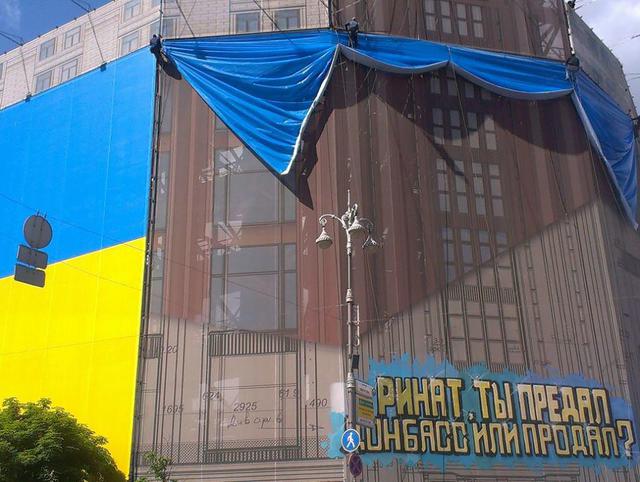 Akhmetov hat die ukrainische Flagge Offensive ihm verschlossen und etikettiert Putin. Fotobericht + VIDEO Ахметов закрыл украинским флагом обидные для него и для Путина надписи. ФОТОрепортаж+ВИДЕО