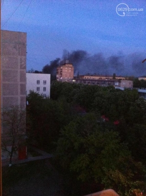 Im Zentrum von Mariupol Reifen an der militärischen Einheit verbrennen die Schüsse gehört, sitzen die Flughafen Hubschrauber nach unten. Bildergeschichte